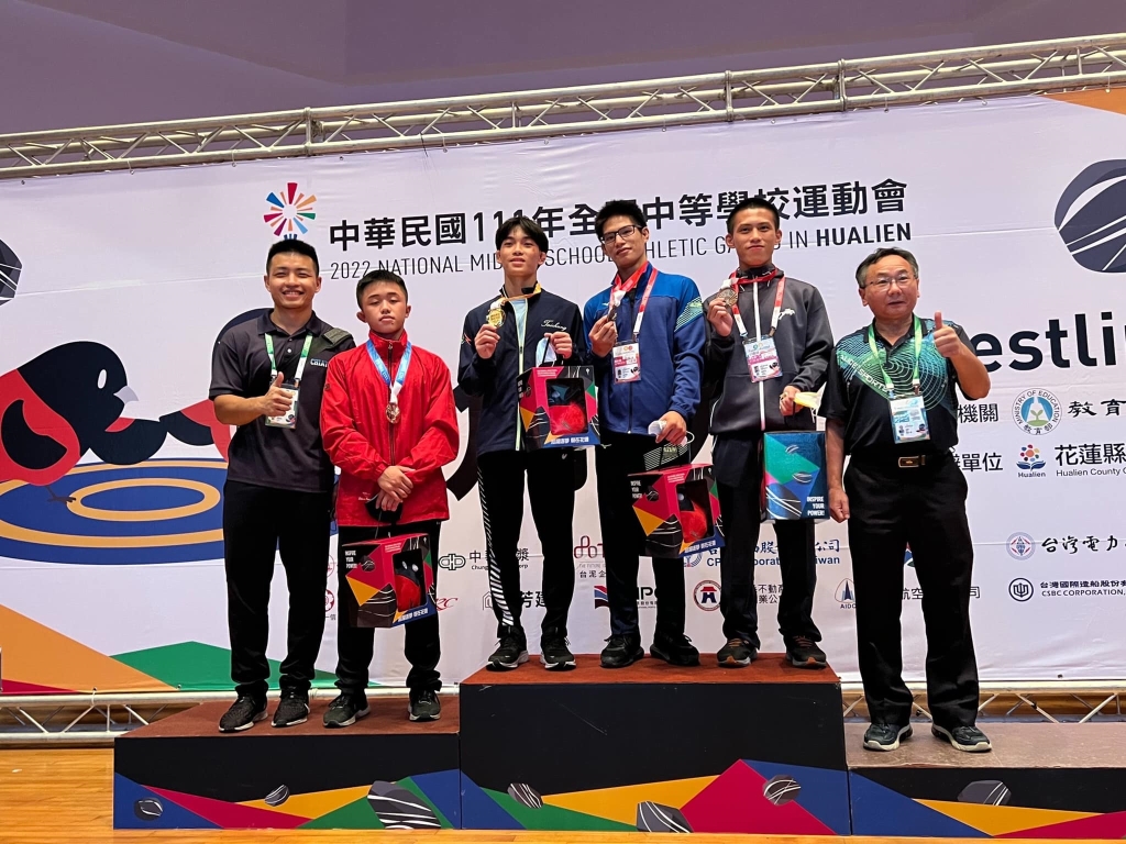 侯文健同學（左2）榮獲第一級銀牌於頒獎台與蔡吉郎校長（右1）及許凱翔教練（左1）合影